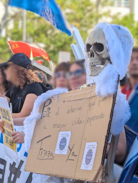 Manifestación de personal interino contra el abuso de temporalidad con una figura de esqueleto y un cartel “Fijeza Ya”.